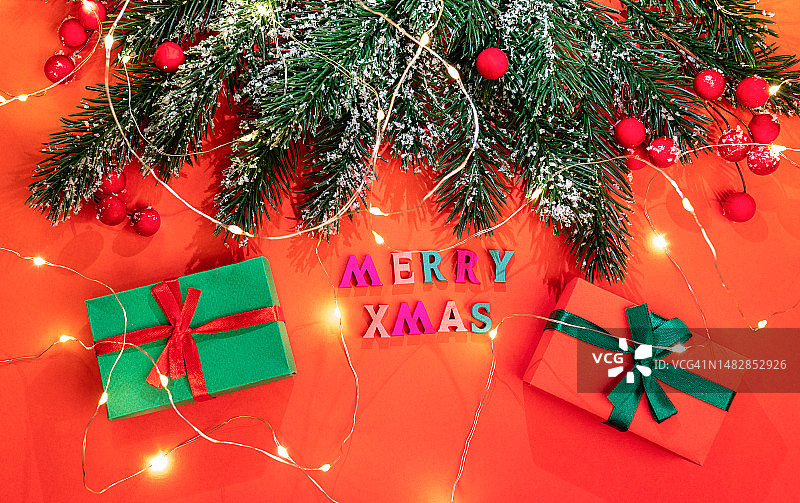 带有冷杉树枝、雪花、浆果、圣诞灯饰、彩色字母礼品盒的圣诞贺卡，罗马尼亚图片素材