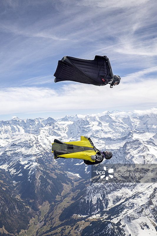 翼装飞行员在群山之上并排飞行图片素材