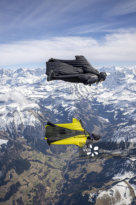 翼装飞行员在群山之上并排飞行图片素材