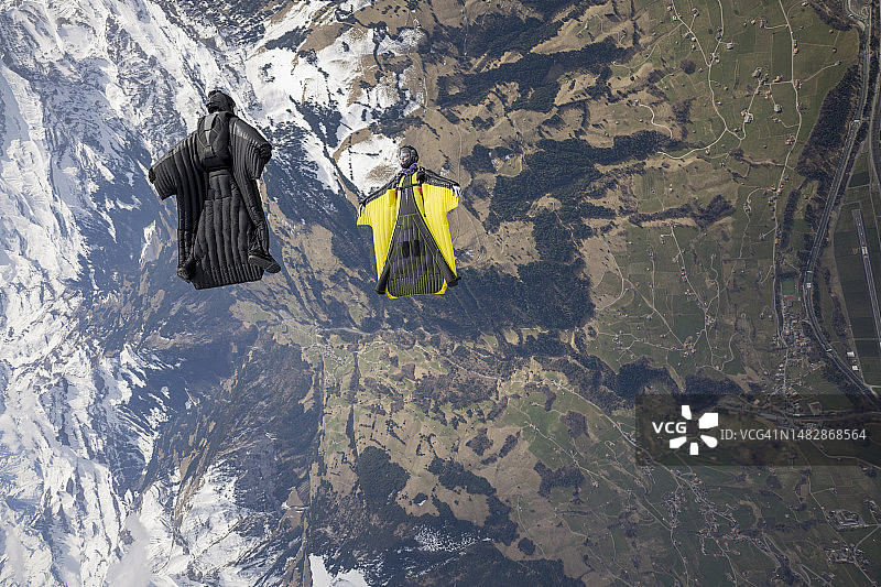 翼装飞行员在群山之上并排飞行图片素材