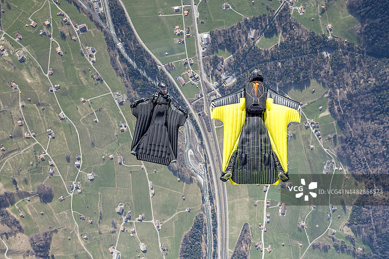 翼装飞行员在群山之上并排飞行图片素材