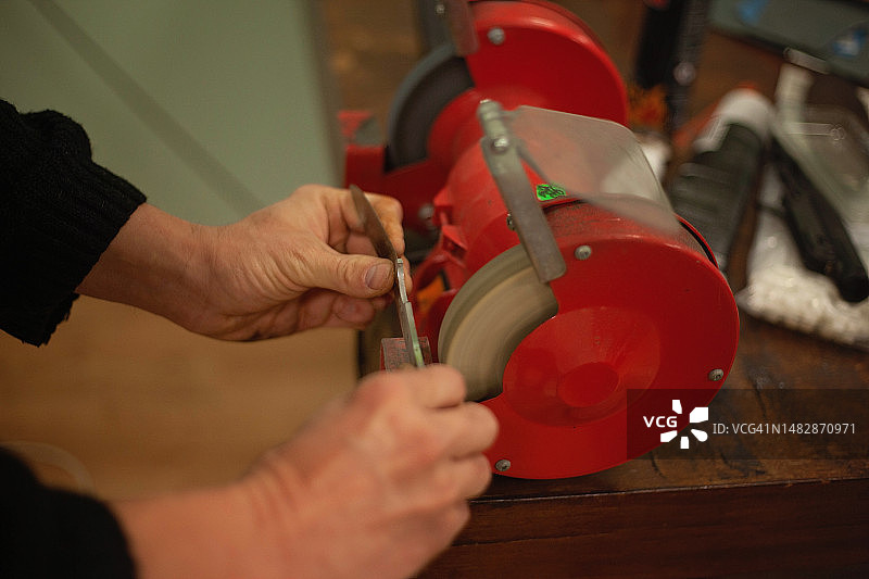 磨刀师傅正在研磨和抛光刀刃图片素材