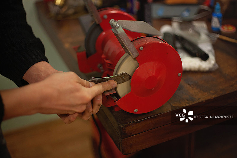 磨刀师傅正在研磨和抛光刀刃图片素材