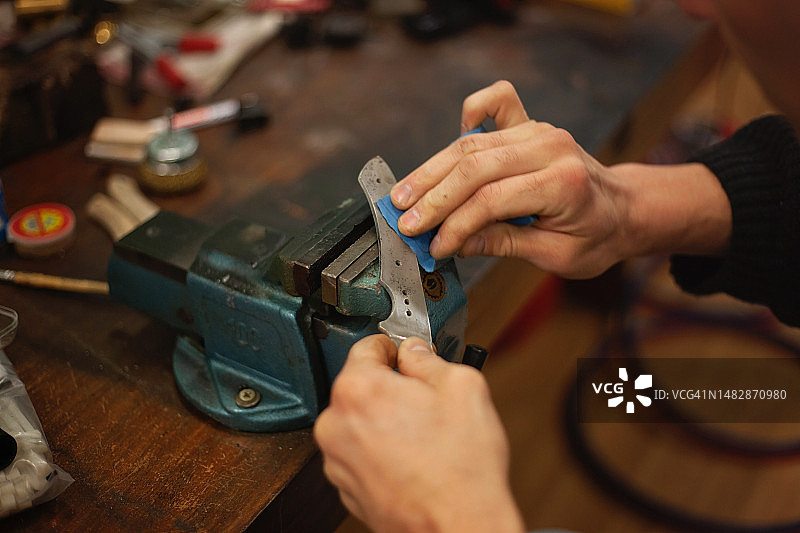 刀匠用砂纸打磨抛光刀刃图片素材