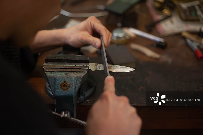 磨刀师傅在打磨刀刃图片素材