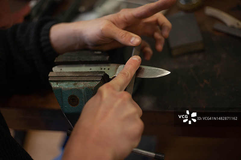 磨刀师傅在打磨刀刃图片素材