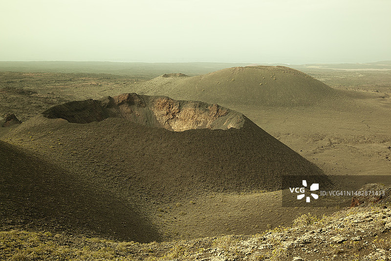在怪异的超凡脱俗的光线下，宛如外星行星的火山景观图片素材