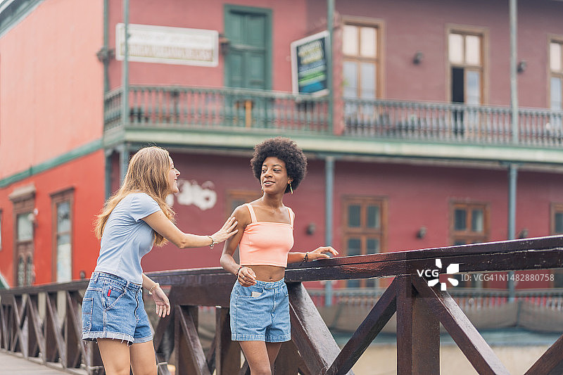 两个朋友在城市里边走边聊图片素材