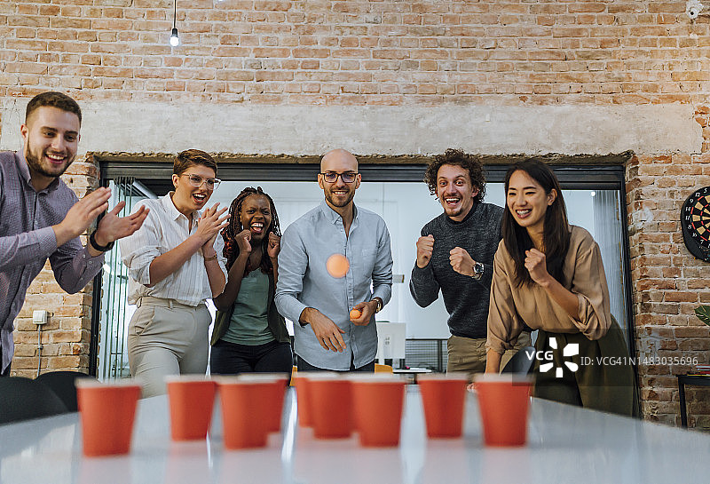 同事在办公室玩啤酒乒乓图片素材