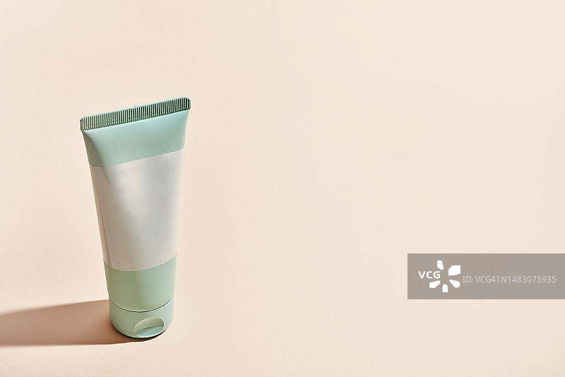 粉色背景上的通用绿色乳霜管图片素材