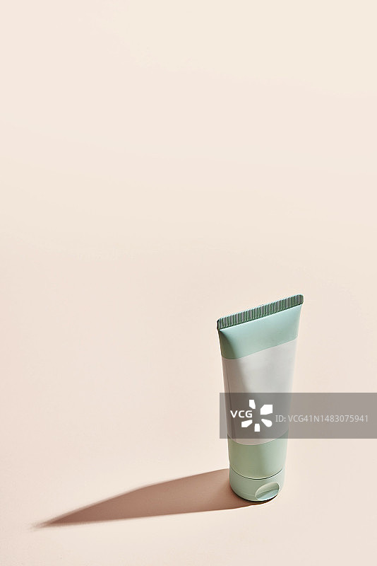 粉色背景上的通用绿色乳霜管图片素材