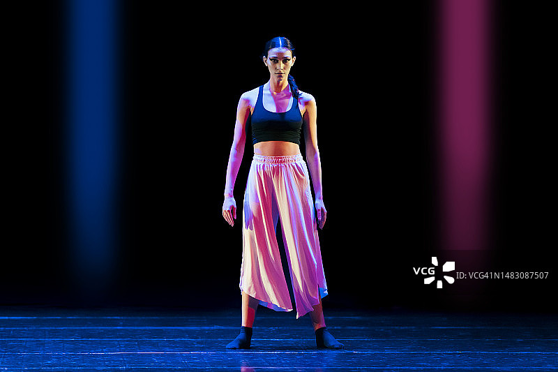 少女在舞台上跳着现代舞，灯光绚丽图片素材