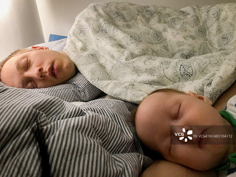 疲惫的父亲和新生儿的睡前时光图片素材