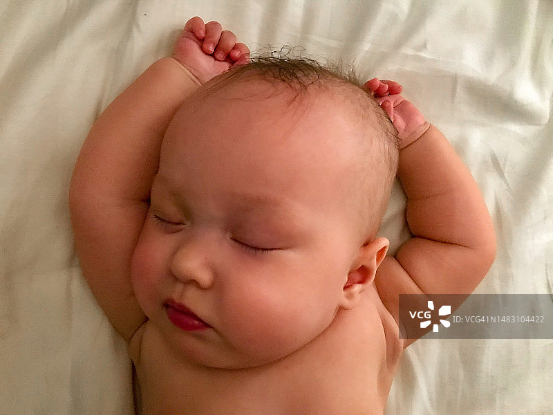 一个婴儿在床上舒适地睡觉图片素材