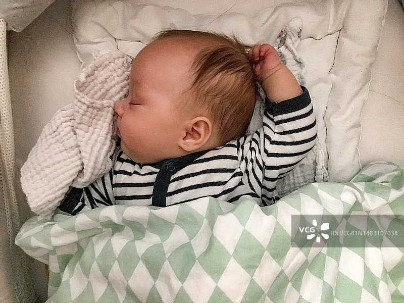 婴儿舒适地睡在婴儿床图片素材