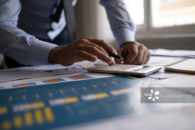 商务会计概念，商务人士使用计算器和电脑，办公室预算和贷款文件图片素材