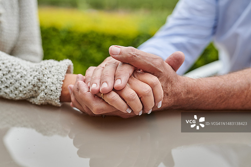 男人在桌旁紧握女人的手图片素材