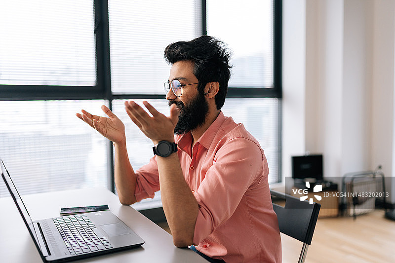 戴眼镜的印度商人通过笔记本电脑进行在线视频通话图片素材