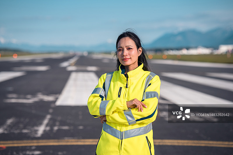 在跑道上的亚洲女机场运营员图片素材