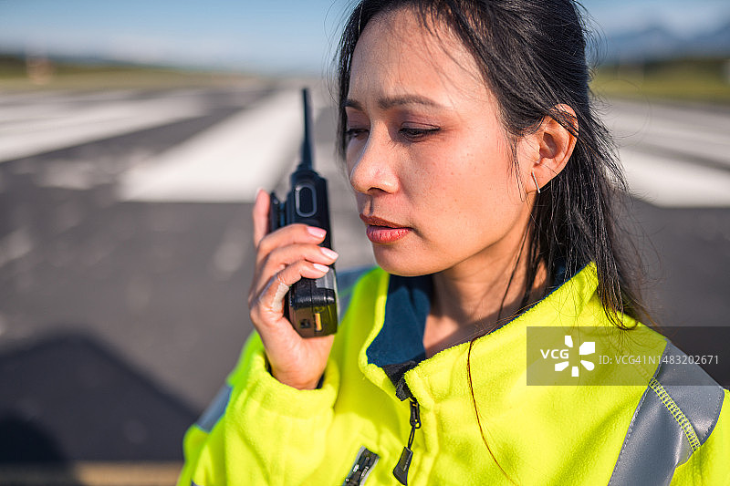 在跑道上的亚洲女机场运营员图片素材