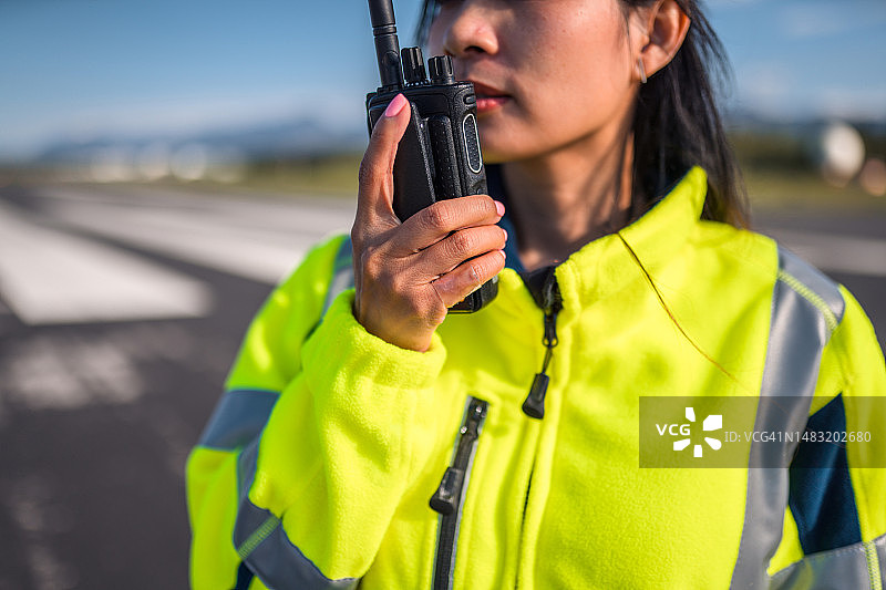 亚洲女空勤人员与空中交通管制员沟通图片素材