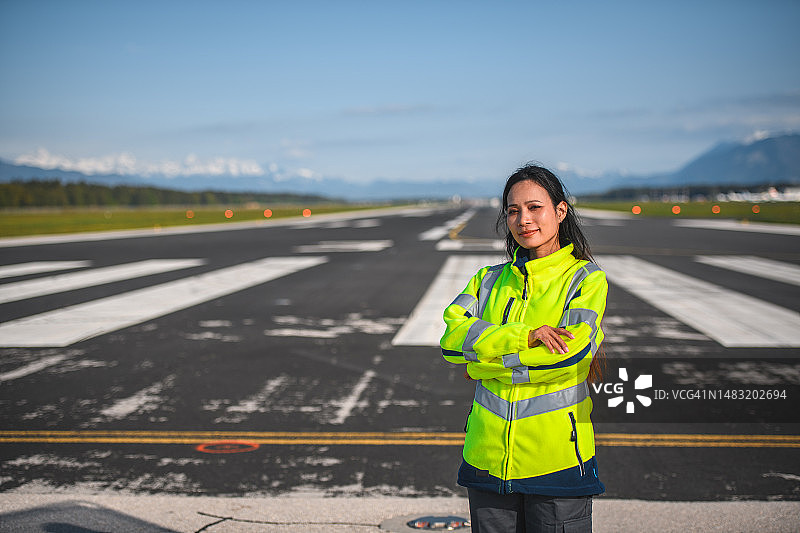 在跑道上的亚洲女机场运营员图片素材