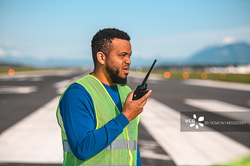 拉丁裔机场运营官在跑道观察情况图片素材