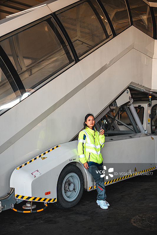 在舷梯旁的亚洲女机场工作人员图片素材
