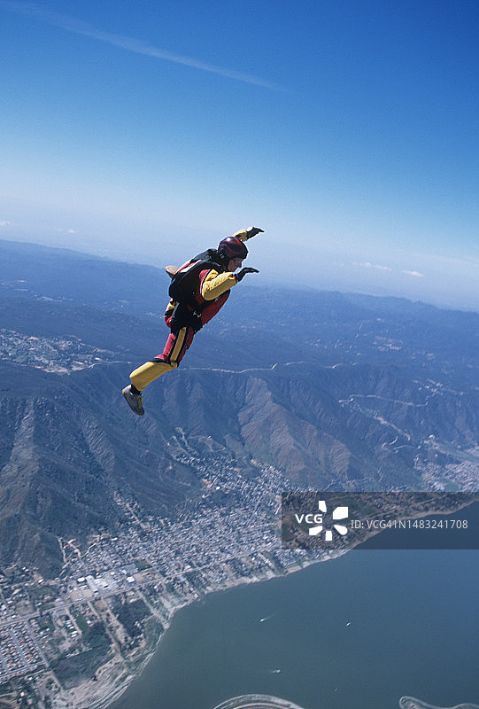 跳伞运动员在湖泊和城市区域上空自由落体图片素材