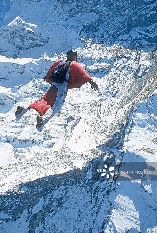 翼装飞行员翱翔于冰川山脉之上图片素材