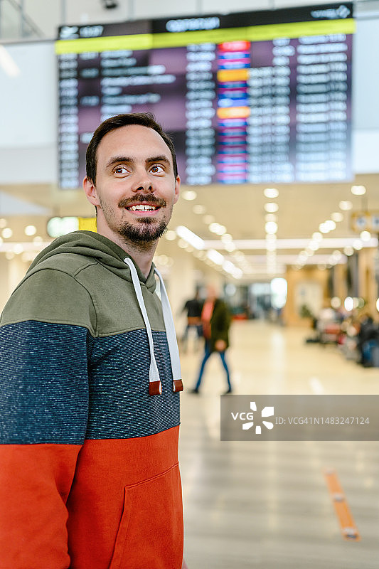 年轻男人在国际机场查看航班信息图片素材