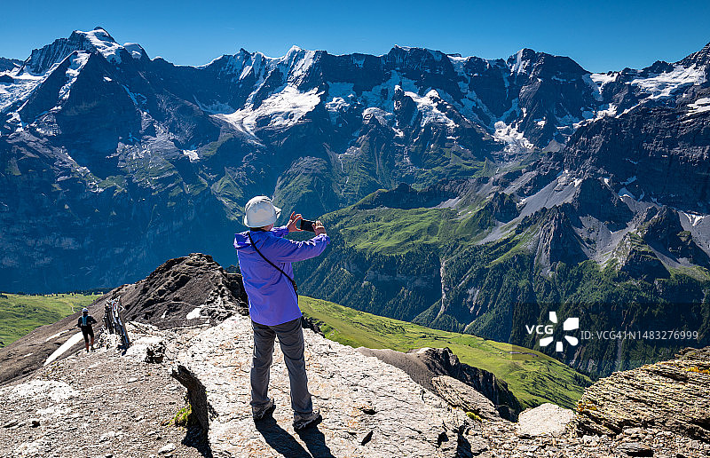 瑞士旅行：年长的女人拍摄瑞士阿尔卑斯山图片素材