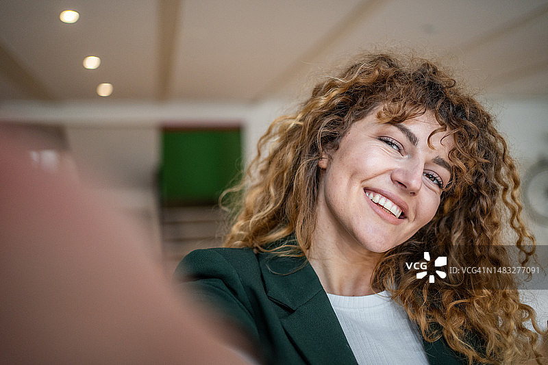 身穿绿色休闲西装在自助餐厅自拍的卷发年轻漂亮女孩图片素材