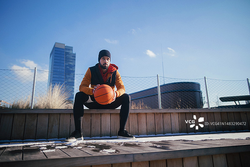 坐在篮球场上的年轻的多种族男人图片素材