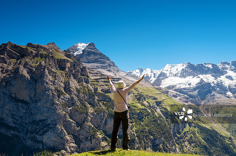 瑞士旅行：中年妇女欣赏少女峰地区的瑞士阿尔卑斯山美景图片素材