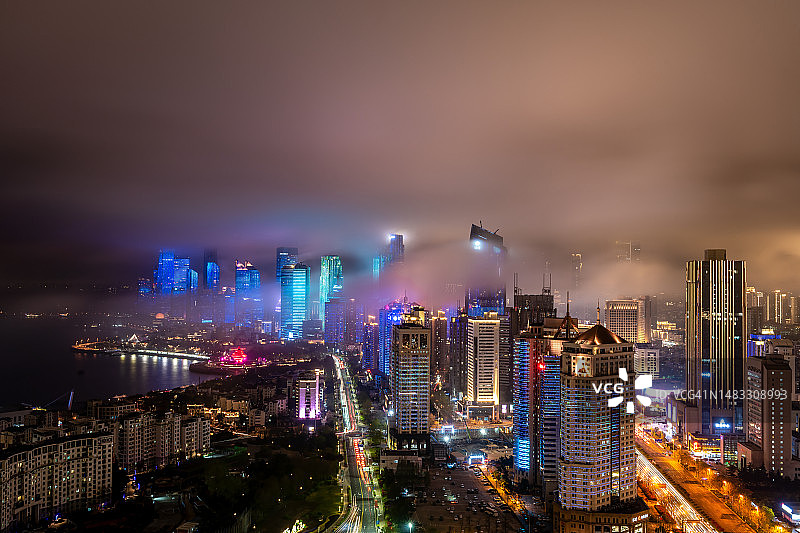 夜幕薄雾下的青岛城市天际线灯光秀图片素材