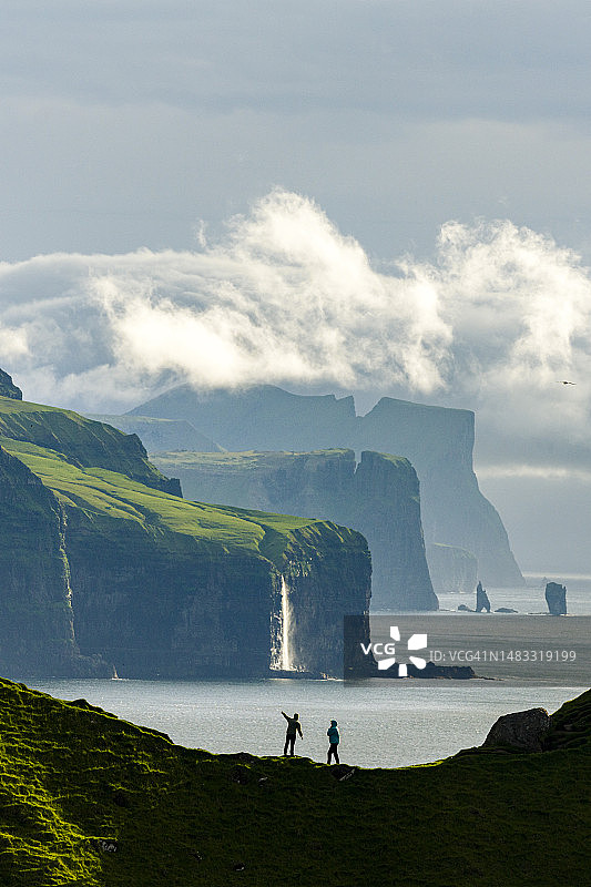 游客悬崖观赏瀑布剪影图片素材