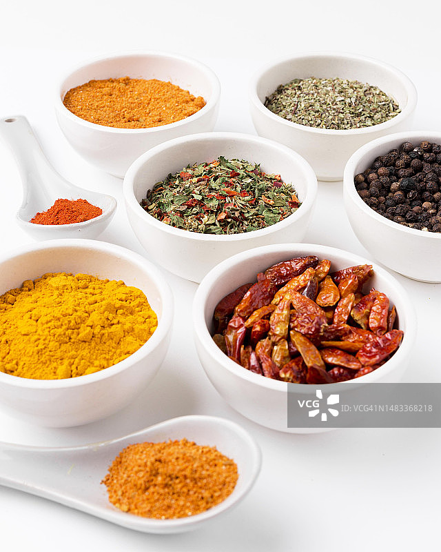 白色背景下碗中各种香料特写图片素材