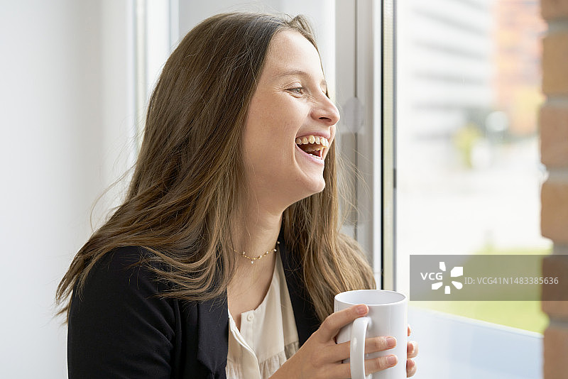 手拿咖啡杯面带微笑的美丽女子正面肖像图片素材