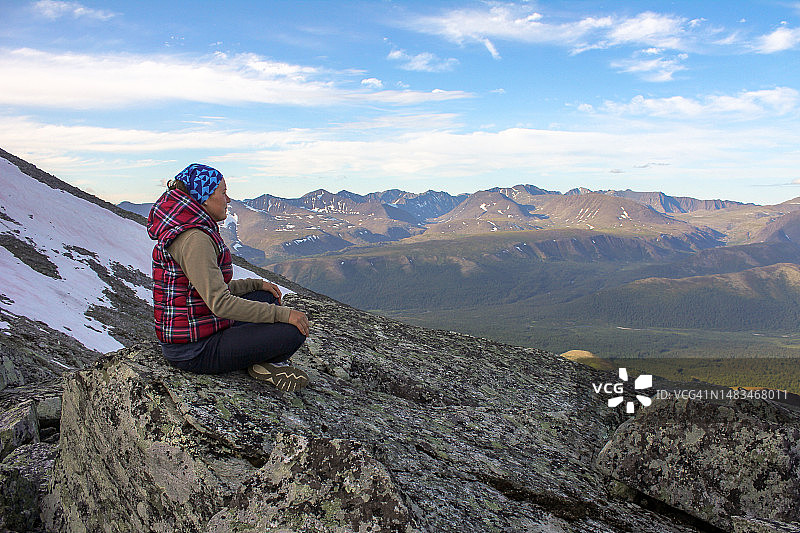 坐在俄罗斯乌拉尔山脉莲花姿势的女人图片素材