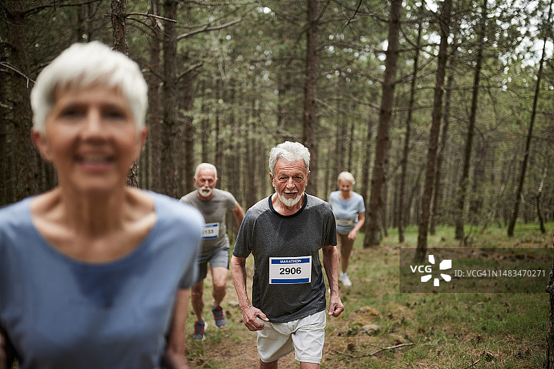 年长的男人和其他老年人在森林里跑马拉松图片素材