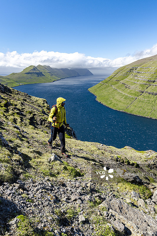 徒步者在峡湾之上的山脊上行走图片素材