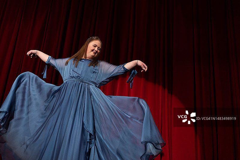 在舞台上跳舞的唐氏综合征年轻女人图片素材