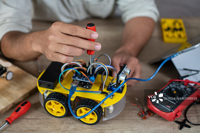 男子制作无人驾驶机器人汽车原型特写图片素材
