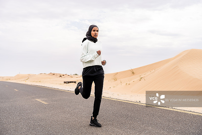 美丽的阿拉伯运动妇女戴着头巾在户外训练，阿拉伯联合酋长国图片素材