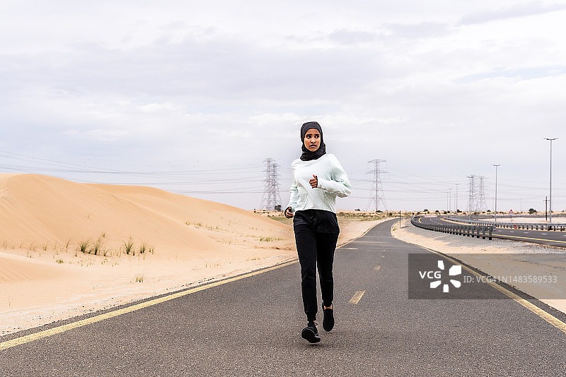 美丽的阿拉伯运动妇女戴着头巾在户外训练，阿拉伯联合酋长国图片素材