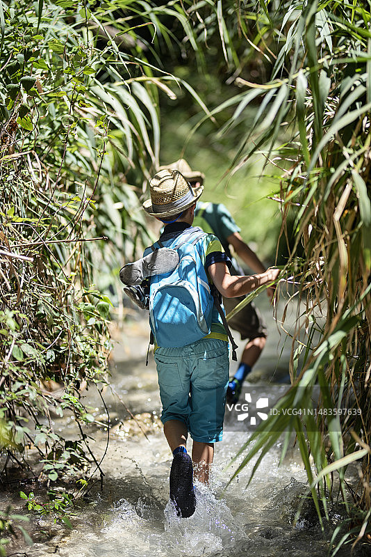 在安达卢西亚山区溪流中徒步的小男孩图片素材