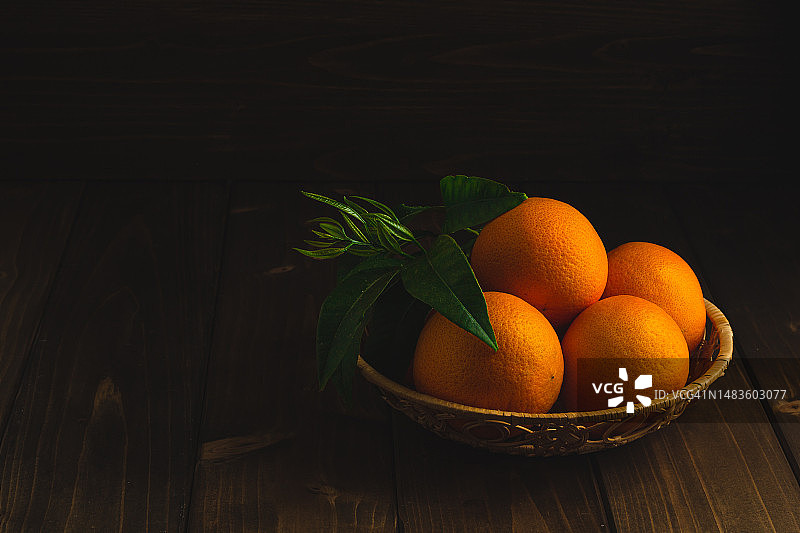 棕色木头上的带绿叶的橙子图片素材