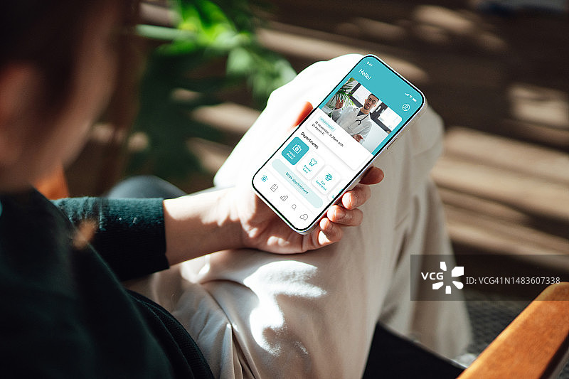年轻女人通过智能手机进行线上医疗预约图片素材