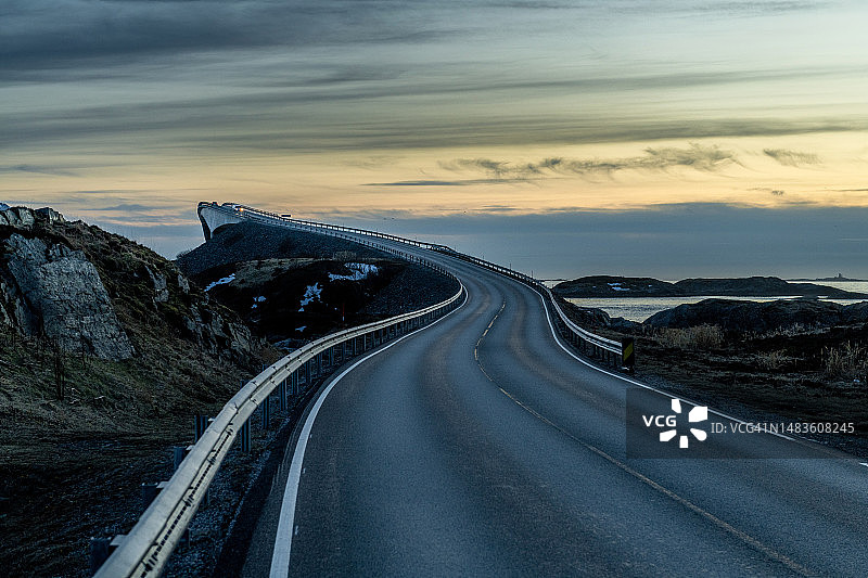 日落时分通往山脉的空旷道路，位于挪威大西洋之路图片素材